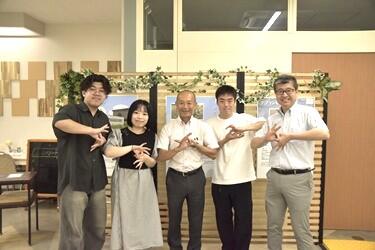 学長、大杉教授と学生が並んで記念写真