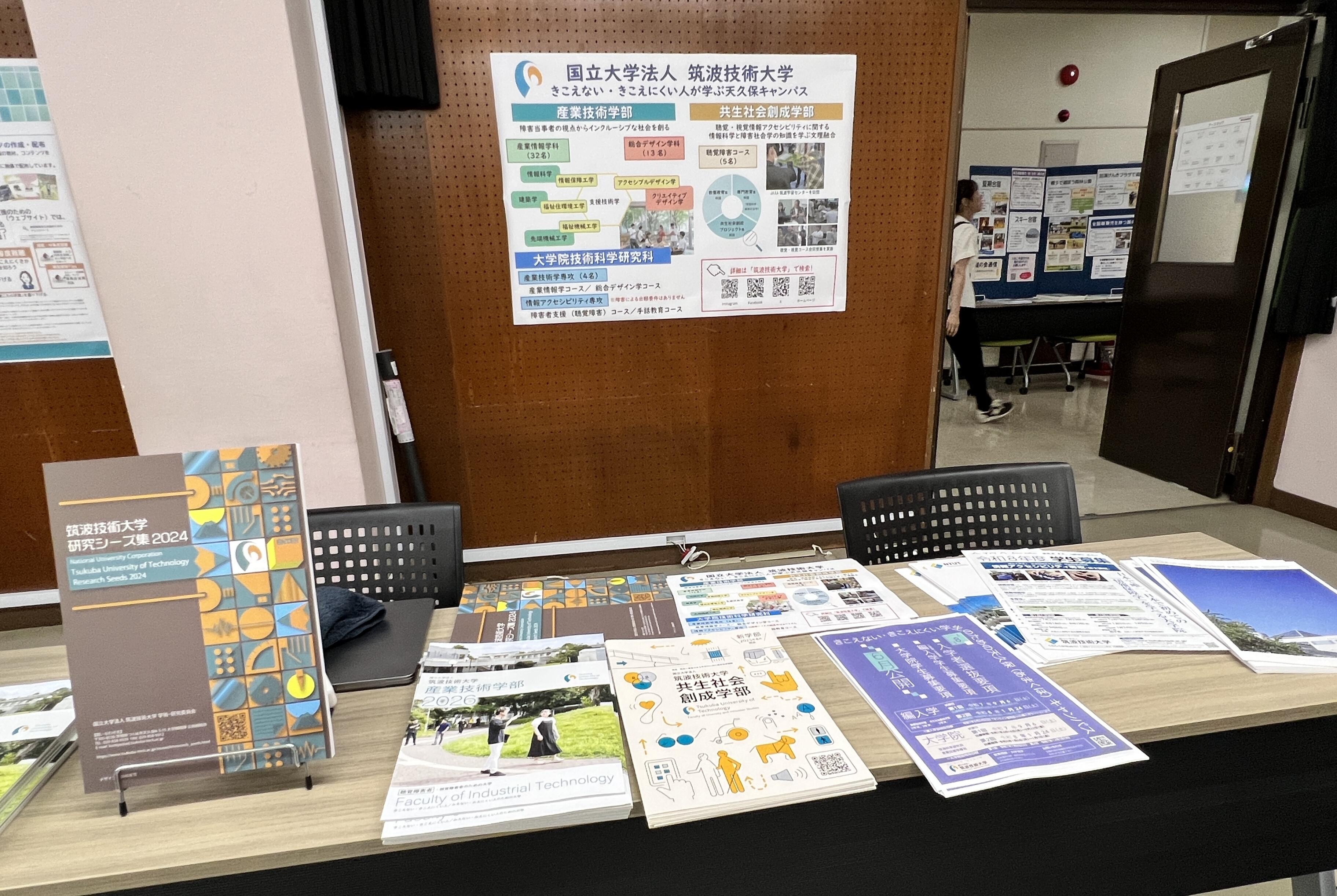 本学のブースに学部案内等の冊子が並んでいる。