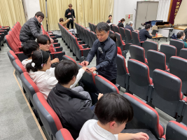 弓を鉛筆に例えて、参加者一人一人が持つ鉛筆を使って弓の持ち方を説明する様子