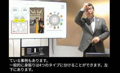 配信中の画像。講師と会場モニター、文字通訳が写っている。